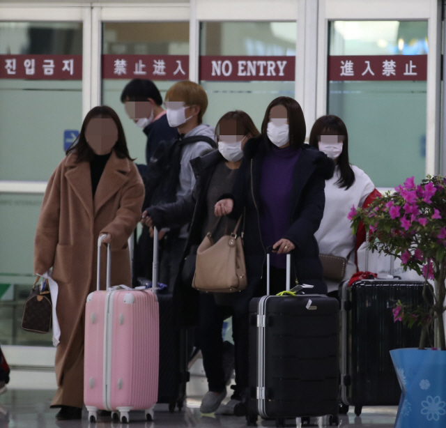 지난 24일 김포공항에서 마스크를 쓴 이용객들이 이동하고 있다. /연합뉴스