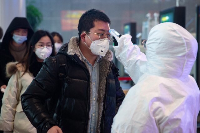 27일(현지시간) 중국 장쑤성 난징에 있는 기차역에서 의료진이 승객들의 체온을 측정하고 있다. /난징=EPA연합뉴스