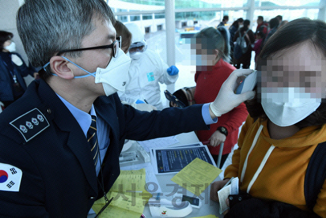 ‘우한 폐렴’ 확진 환자가 발생한 20일 중국 우한발 여객기로 입국하는 사람들이 인천국제공항에서 발열 검사를 받고 있다./영종도=이호재기자