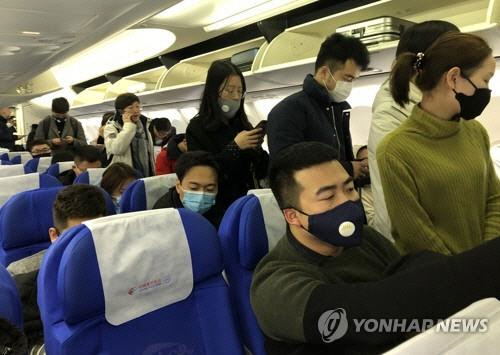 지난 21일 중국 상하이(上海)를 출발해 우한(武漢)으로 향하는 항공기에 탄 승객들이 신종 코로나바이러스 감염을 막고자 마스크를 쓰고 있다./연합뉴스