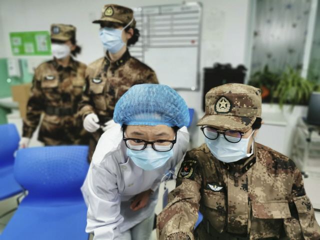 중국 인민해방군 소속 의료진이 26일(현지시간) 후베이성 우한의 진인탄 병원에서 마스크를 착용한 채 업무를 보고 있다. /우한=AP연합뉴스