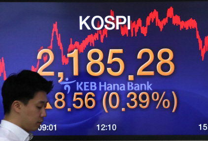 코스피가 8.56포인트 오른 2,185.28로 장을 마감한 29일 서울 중구 KEB 하나은행 딜링룸에서 한 딜러가 전광판 앞을 지나고 있다. /연합뉴스