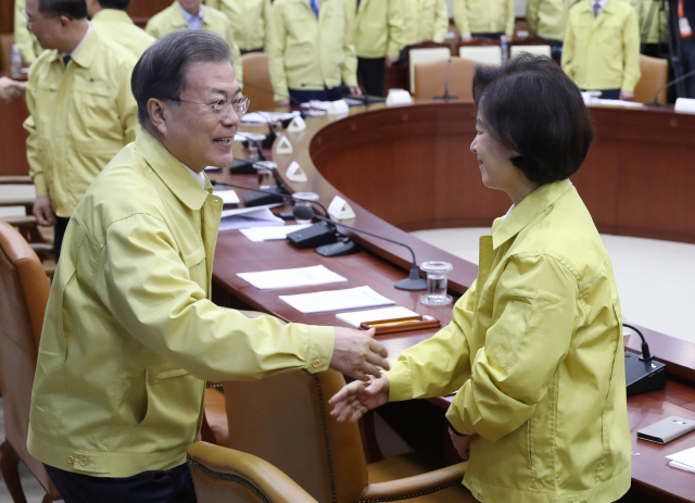 문재인 대통령이 30일 오전 정부서울청사에서 열린 신종 코로나바이러스 감염증 대응 종합 점검회의에서 추미애 장관과 인사하고 있다./연합뉴스