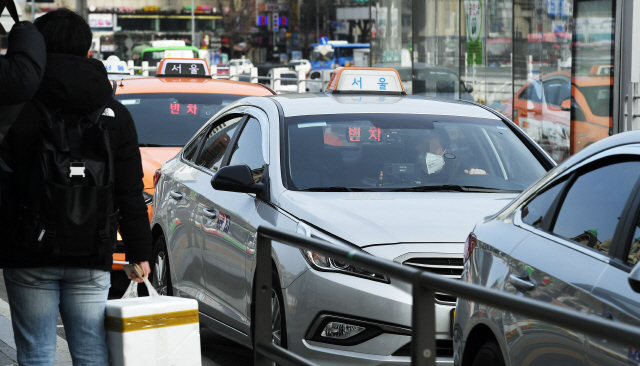 신종 코로나바이러스 공포가 확산되던 지난 29일 서울역 인근 정류장에서 마스크를 쓴 택시기사들이 승객을 기다리고 있다. /오승현기자