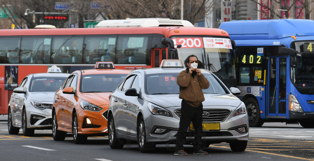 신종 코로나바이러스 공포가 확산되던 지난 29일 서울역 인근 정류장에서 한 택시기사가 손님을 기다리며 마스크를 고쳐 쓰고 있다. /오승현기자