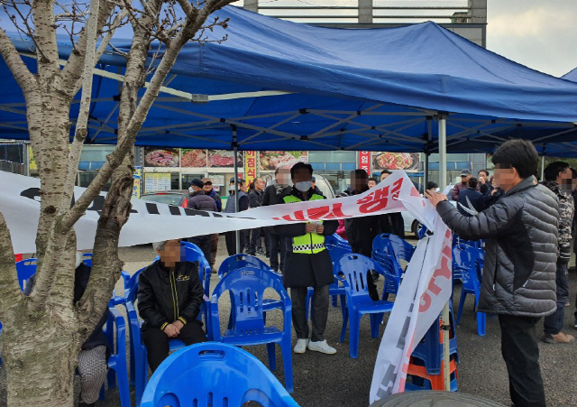 충남 아산시 초사2동 주민들이 31일 중국 우한 교민이 격리 수용될 경찰인재개발원 앞 천막에 설치돼 있던 ‘교민 수용 철회’요구 현수막을 철거하고 있다. /아산=연합뉴스