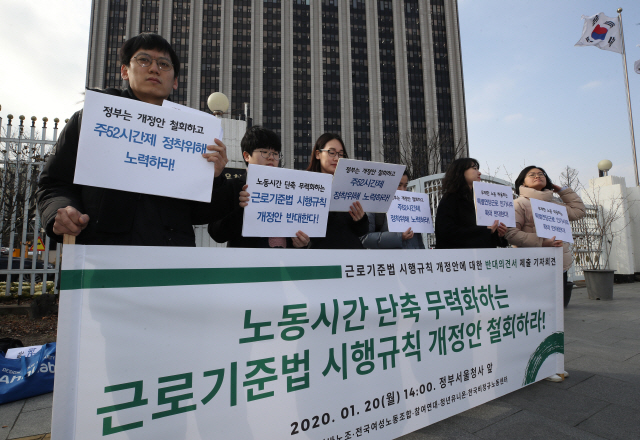 지난 20일 오후 정부서울청사 앞에서 열린 ‘근로기준법 시행규칙 개정안에 대한 반대의견서 제출 기자회견’에서 참가자들이 손팻말을 들고 있다. /연합뉴스