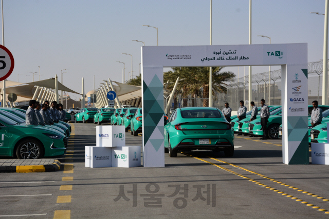 현대자동차가 지난달 22일 사우디아라비아 킹 칼리드(King Khalid) 국제공항에서 사우디 최대 운수기업인 알 사프와에 공항택시로 사용될 신형 쏘나타를 인도하고 있다. 현대차는 알 사프와와 1,000대 공급계약을 체결했고 모든 택시에 대해 최첨단 결제·통역 스크린 등을 장착했다./사진제공=현대차