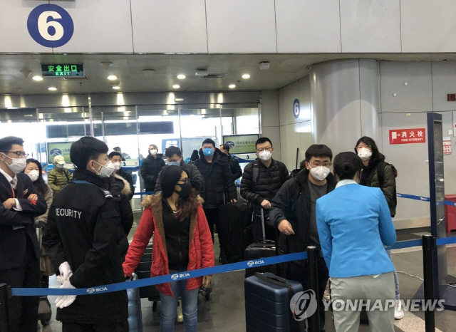 2일 중국 베이징 서우두공항에서 승객들이 신종 코로나바이러스 예방을 위해 마스크를 쓴 채 공항에 들어가려고 기다리고 있다. / 사진=연합뉴스
