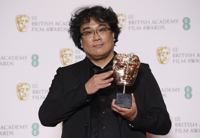 봉준호 감독이 2일(현지시간) 영국 런던 로열 앨버트 홀에서 열린 영국영화TV예술아카데미(BAFTA) 시상식에서 영화 ‘기생충’으로 외국어영화상을 받은 뒤 상과 함께 포즈를 취하고 있다. /연합뉴스=로이터
