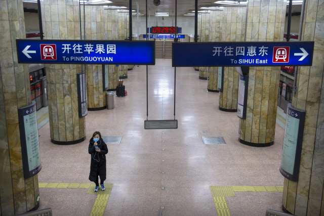 3일 오전 중국 베이징시에서 마스크를 쓴 한 여성이 출근시간대에 텅 빈 지하철 역사를 지나가고 있다. 신종 코로나바이러스 감염증의 확산을 막기 위해 중국 각 지방정부들이 춘제 연휴를 오는 9일까지 연장하면서 도심 지역 곳곳에 인적이 뚝 끊겼다. /베이징=AP연합뉴스