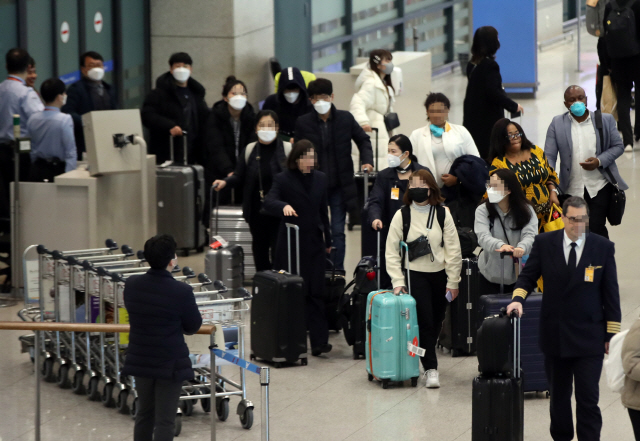 3일 오후 인천국제공항 1터미널에서 입국객들이 마스크를 쓰고 입국하고 있다. /연합뉴스