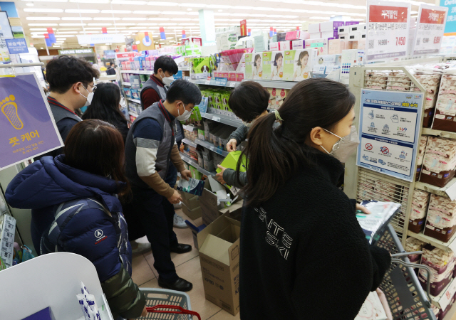 서울시내의 한 대형마트 마스크 매대에서 4일 내외국인 고객들이 앞다퉈 제품을 사고 있다. 이 마트는 ‘싹쓸이’ 쇼핑을 방지하고자 고객 1명당 10개로 마스크 판매를 제한했다. /연합뉴스