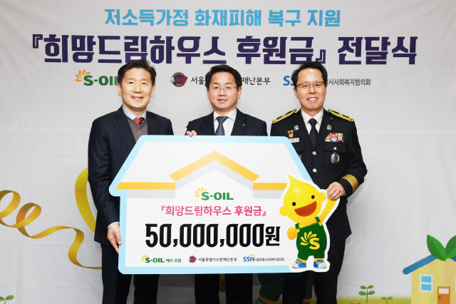 선진영(가운데) 에쓰오일 전무가 5일 서울 본사에서 저소득가정 화재 피해 복구 지원금 5,000만원을 전달한 뒤 김현훈(왼쪽) 서울시 사회복지협의회장, 이홍섭 서울소방재난본부 소방행정과장과 기념촬영을 하고 있다. /사진제공=에쓰오일