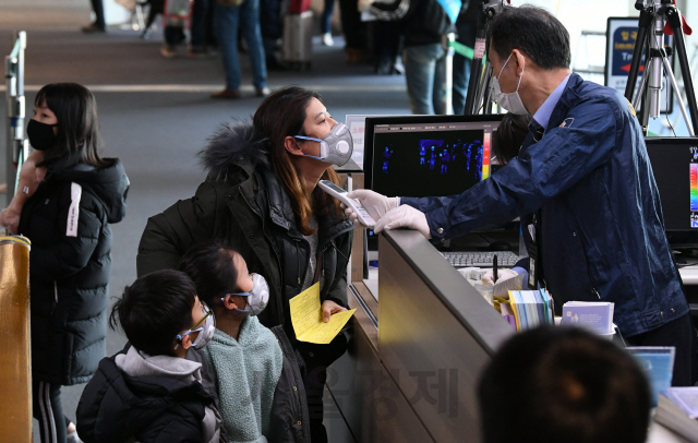 최근 중국발 항공기를 타고 인천공항 제1 터미널을 통해 입국한 여행객들이 검역소에서 체온을 재고 있다.  /영종도=이호재기자