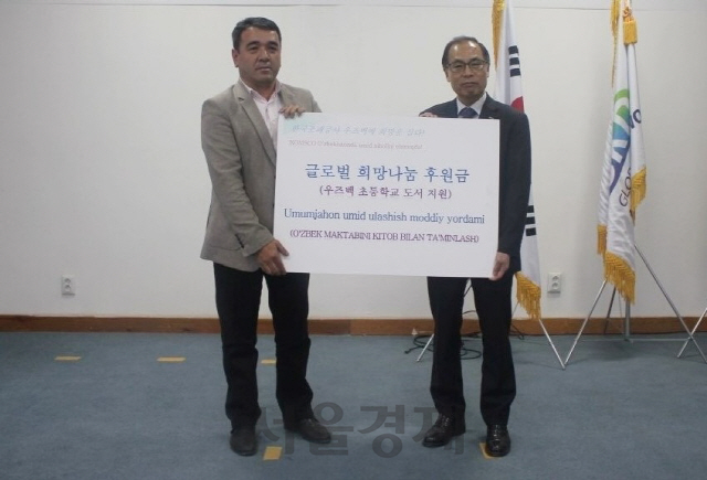한국조폐공사 정상윤(사진 오른쪽) 기획이사가 도서 2,000여권을 지원하는 후원금을 전달하고 있다. 사진제공=한국조폐공사