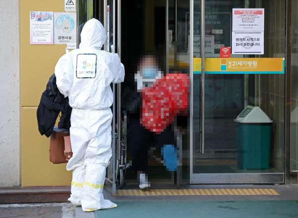 국내 18번째 신종 코로나바이러스 감염증 확진자가 5일 오전 광주 21세기병원에서 음압 병동이 마련된 전남대병원으로 가기 위해 병원을 나서고 있다./연합뉴스