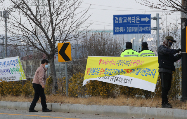 지난 3일 오후 충남 아산시 사초동 우한교민 임시생활시설인 경찰인재개발원 인근에 현수막업체 직원들이 우한교민을 격려하는 아산 시민들의 현수막을 부착하고 있다. /아산=연합뉴스