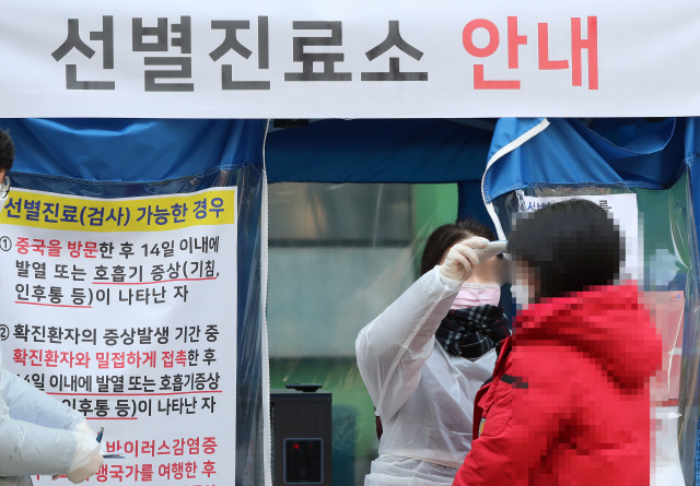 10일 오후 서울 중구보건소 선별진료소를 찾은 한 시민이 체온을 재고 있다. /연합뉴스