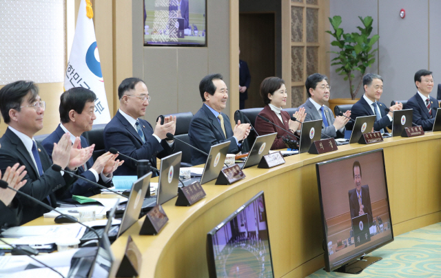 정세균 국무총리 등 국무위원들이 11일 정부세종청사에서 열린 국무회의에서 영화 ‘기생충’ 팀의 아카데미 시상식 4관왕 소식에 박수를 치며 축하하고 있다./연합뉴스