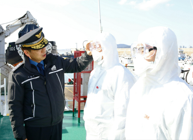 조현배(왼쪽) 해양경찰청장이 불법조업 외국 어선을 단속하는 임무를 맡고 있는 서해5도특별경비단 1002함을 방문해 외국인 선원 접촉 시 사용하는 개인보호장비를 점검하고 있다.     /사진제공=해경