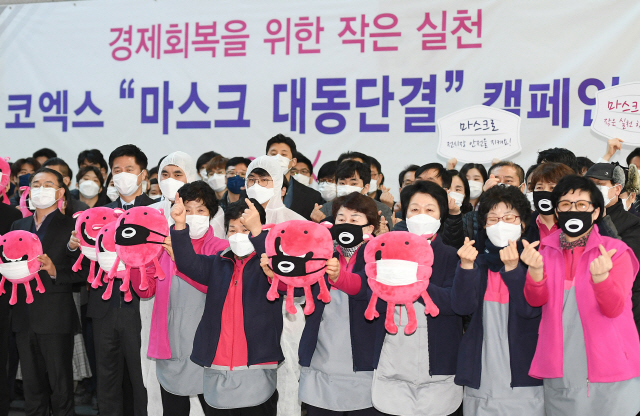 코엑스 임직원들이 11일 서울 강남구 코엑스에서 경제회복을 위한 작은 실천, 코엑스 ‘마스크 대동단결 캠페인’을 벌이고 있다. 신종 코로나바이러스 감염증 확산으로 전시를 취소했던 코엑스는 12일부터 전시를 재개한다./오승현기자