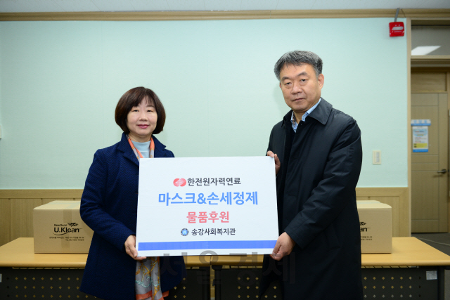 한전원자력연료 이선남(사진 오른쪽) 총무팀장이 송강사회복지관 김영미(〃왼쪽) 관장에게 마스크와 손세정제를 전달하고 있다. 사진제공=한전원자력연료