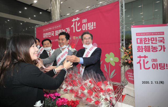 이성희(오른쪽) 농협중앙회 회장이 지난 13일 서울 농협중앙회에서 열린 ‘화훼류 소비촉진 행사’에서 출근하는 임직원에게 꽃을 나눠주고 있다. /사진제공=농협중앙회