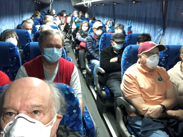 신종 코로나바이러스(코로나 19) 감염자가 집단 발생해 일본 요코하마항 크루즈 터미널에 발이 묶여 있던 크루즈선 ‘다이아몬드 프린세스’호의 미국인 승선객들이 17일 배에서 내려 도쿄 하네다 공항으로 가는 셔틀버스에 탑승해 있다. /요코하마=로이터연합뉴스