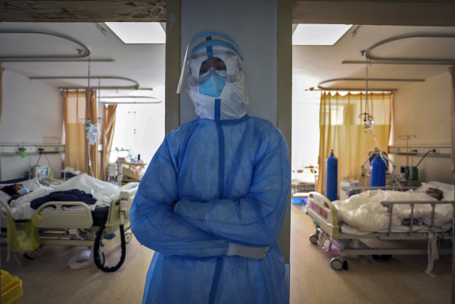 서서 쪽잠 자는 중국 의료진  중국 후베이성 우한의 한 병원에서 16일 한 의료인이 신종 코로나바이러스 감염증(코로나19) 환자들을 돌보던 중 벽에 기대 선 채로 쪽잠을 자고 있다./우한=AP연합뉴스