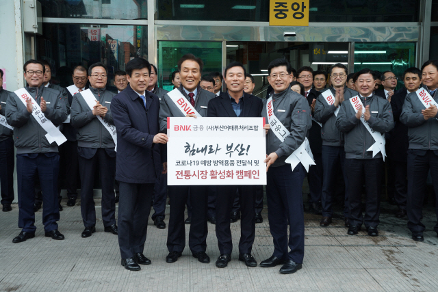 김지완(왼쪽 두번째) BNK금융그룹 회장과 빈대인(〃네번째) BNK부산은행장이 17일 부산 자갈치시장에서 진행된 전통시장 활성화 행사에서 송종홍(〃첫번째) 부산 중구부구청장과 김종진(〃세번째) 부산어패류처리조합장에게 코로나19 예방 방역용품을 전달하고 있다. /사진제공=BNK금융