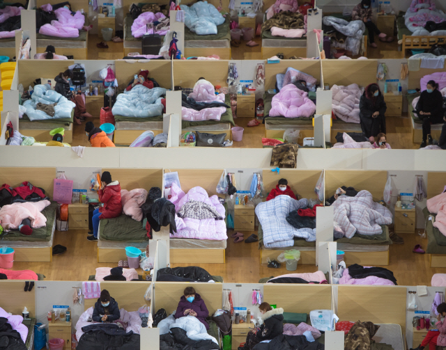 중국 우한의 코로나19 환자들이 18일 우한 스포츠센터에 마련된 임시 치료 시설에서 휴식을 취하고 있다./신화연합뉴스