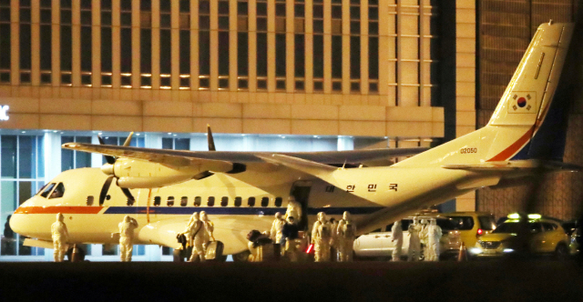 일본에 정박 중인 크루즈선에 탑승했던 한국인 6명과 일본인 배우자 1명을 태운 공군 3호기(VCN-235)가 19일 새벽 김포공항에 착륙했다. 탑승객들이 비행기에서 내려 공항 청사 안으로 향하고 있다. /연합뉴스