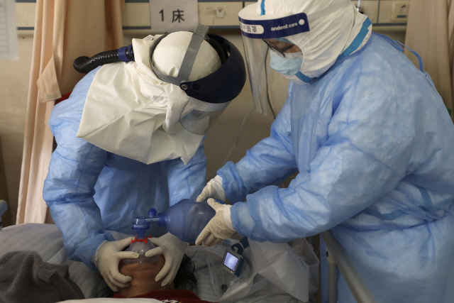 중국 후베이성 우한의 한 병원에서 16일(현지시간) 의료진이 코로나19 환자에게 산소공급 치료를 하고 있다./우한=AP연합뉴스