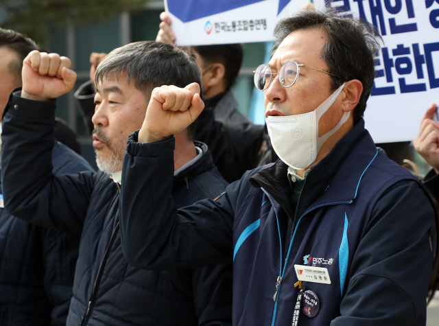 김명환(오른쪽) 민주노총 위원장과 김동명 한국노총 위원장 등 양대노총 지도부가 19일 서울행정법원 앞에서특별연장근로 인가 확대 취소소송 제기 공동기자회견을 열고 구호를 외치고 있다. /연합뉴스