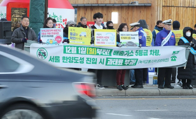 지난해 12월 2일 서울 종로구 광화문광장에서 서울시와 시민단체 관계자들이 ‘녹색교통지역 운행제한 및 미세먼지 시즌제 시행 캠페인’을 하고 있다.  /연합뉴스