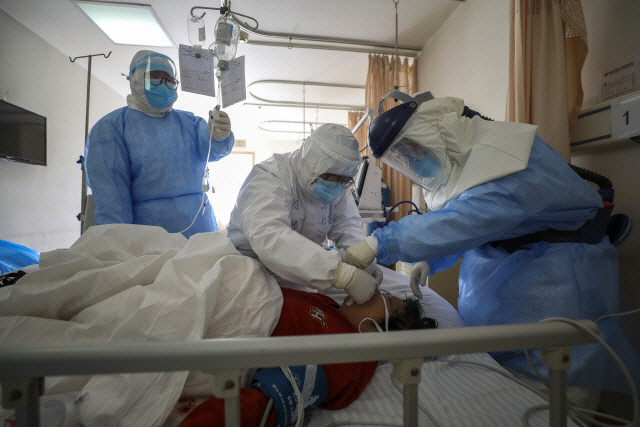 중국 후베이성 우한의 한 병원에서 16일 의료진이 새로 입원한 신종 코로나바이러스(코로나19) 감염증 환자를 치료하고 있다./연합뉴스