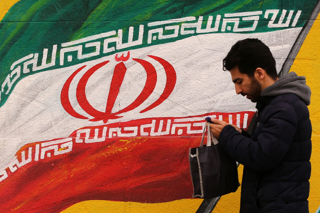 20일(현지시간) 이란 수도 테헤란에서 한 남성이 이란 국기가 그려진 벽화 앞을 지나고 있다. /테헤란=AFP연합뉴스