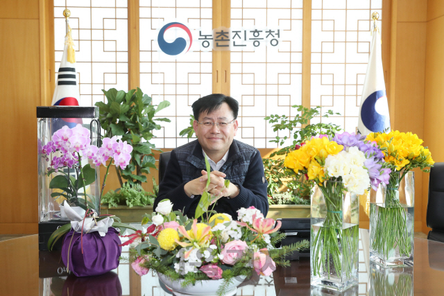 김경규 농촌진흥청장이 화훼농가 살리기 릴레이 캠페인에 동참, 구매한 꽃들을 살펴보고 있다. /사진제공=농진청