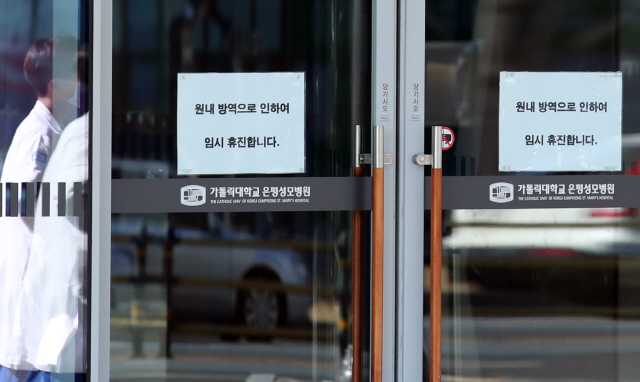 23일 임시휴진 안내문이 부착된 서울 은평구 은평성모병원 입구 앞으로 의료진이 지나가고 있다.   /연합뉴스