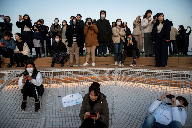 24일 도쿄에서 시민들이 마스크를 쓴 채 야경을 보고 있다./도쿄=로이터연합뉴스