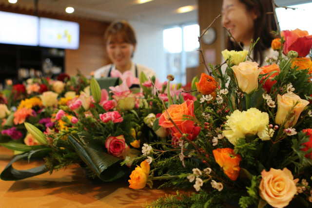 동서발전 직원들이 지난 18일 화훼농가 지원을 위해 꽃을 구매하고 있다./사진제공=동서발전