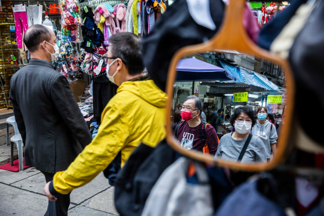 25일 홍콩에서 마스크를 쓴 행인들이 거리를 지나고 있다./홍콩=AFP연합뉴스