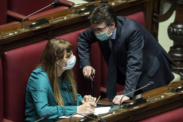 이탈리아에서 신종 코로나바이러스 감염증(코로나19)이 확산하고 있는 가운데 25일(현지시간) 하원 의사당에서 마테오 달로소(오른쪽) 의원과 테레사 발디니 의원이 마스크를 쓴 채 대화를 나누고 있다. /로마=AP연합뉴스