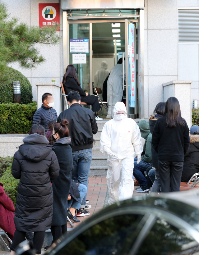 부산 온천교회 신도들이 코로나19 확진 판정을 받자 많은 시민들이 진단검사를 받기 위해 한 보건소 선별진료소 앞에서 대기하고 있다. ‘드라이브 스루’ 방식에 비해 대기자 간 감염 위험이 높고 실내 검체 채취 공간의 소독에도 많은 시간이 걸린다. /연합뉴스