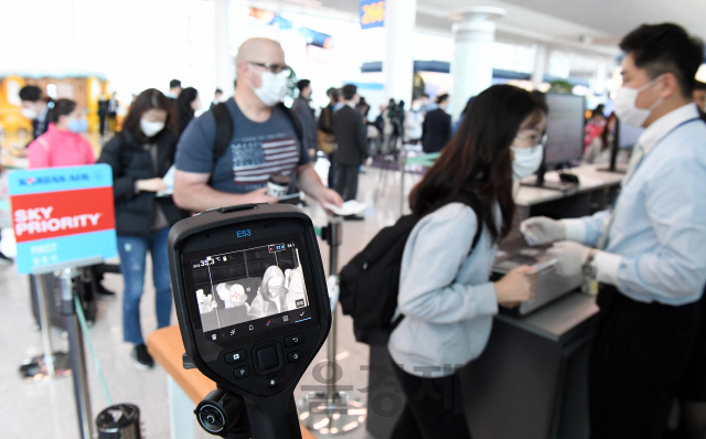 대한항공 관계자들이 28일 인천국제공항 제2터미널 탑승구에서 로스앤젤레스(LA)행 KE017편 탑승 승객에게 열화상 카메라와 휴대용 체온계로 발열 체크를 하고 있다. 대한항공은 인천공항을 출발하는 모든 미국 노선 전편에 대해 발열 체크를 의무화하는 한편 추가적인 기내 소독을 진행하기로 했다./영종도=권욱기자 2020.2.28