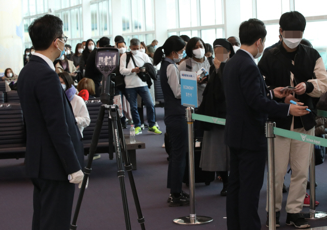 28일 오후 인천국제공항 2터미널 인천발 로스앤젤레스(LA)행 KE017편 탑승구 앞에서 대한항공 직원들이 탑승 승객의 발열 여부를 확인하고 있다./연합뉴스