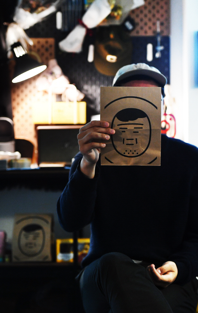 지난 26일 서울 마포구 서교동 작업실에서 작가 키크니가 자신의 만화 캐릭터가 그려진 봉투로 얼굴을 가리고 있다. /오승현기자