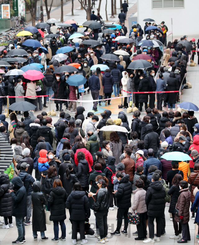 비가 내리는 28일 서울 양천구 목동 행복한백화점에서 열린 마스크 긴급 노마진 판매 행사에서 시민들이 마스크를 구매하기 위해 길게 줄을 서 있다./권욱기자 2020.2.28