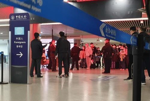 지난 25일 오후 중국 난징공항 입국장에서 한국 승객들이 줄을 서 방역 당국의 조사를 받고 있다. 입국장의 외국인 안내판에 유독 한국어로만 ‘한국인’이라는 글자가 적혀 있다./연합뉴스